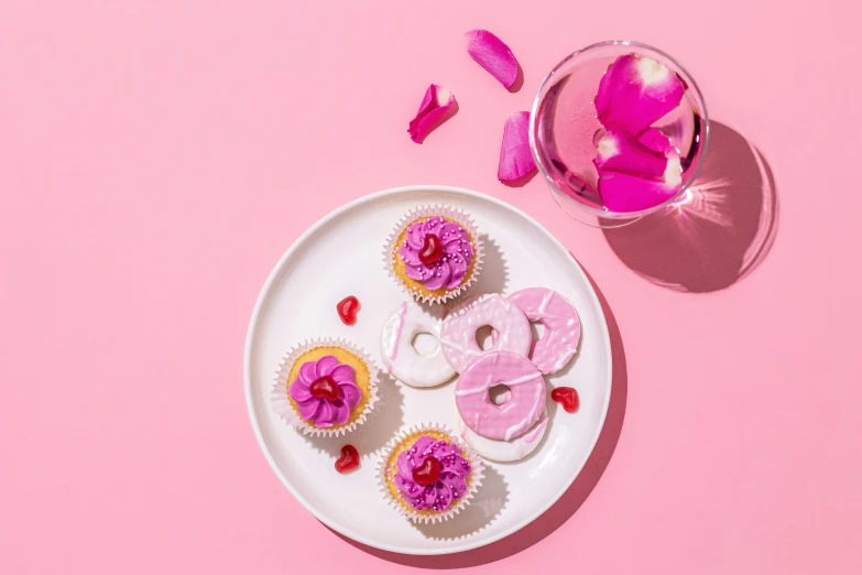 the cupcakes are next to the pink rose