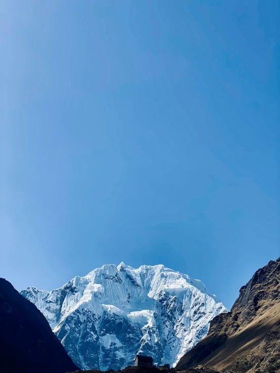 a man stands at the peak of a snowy mountain