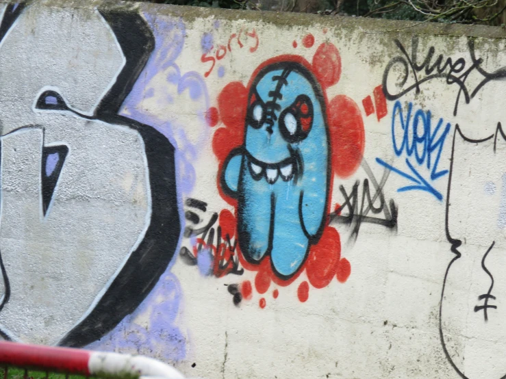 a white wall with colorful graffiti and a black cat