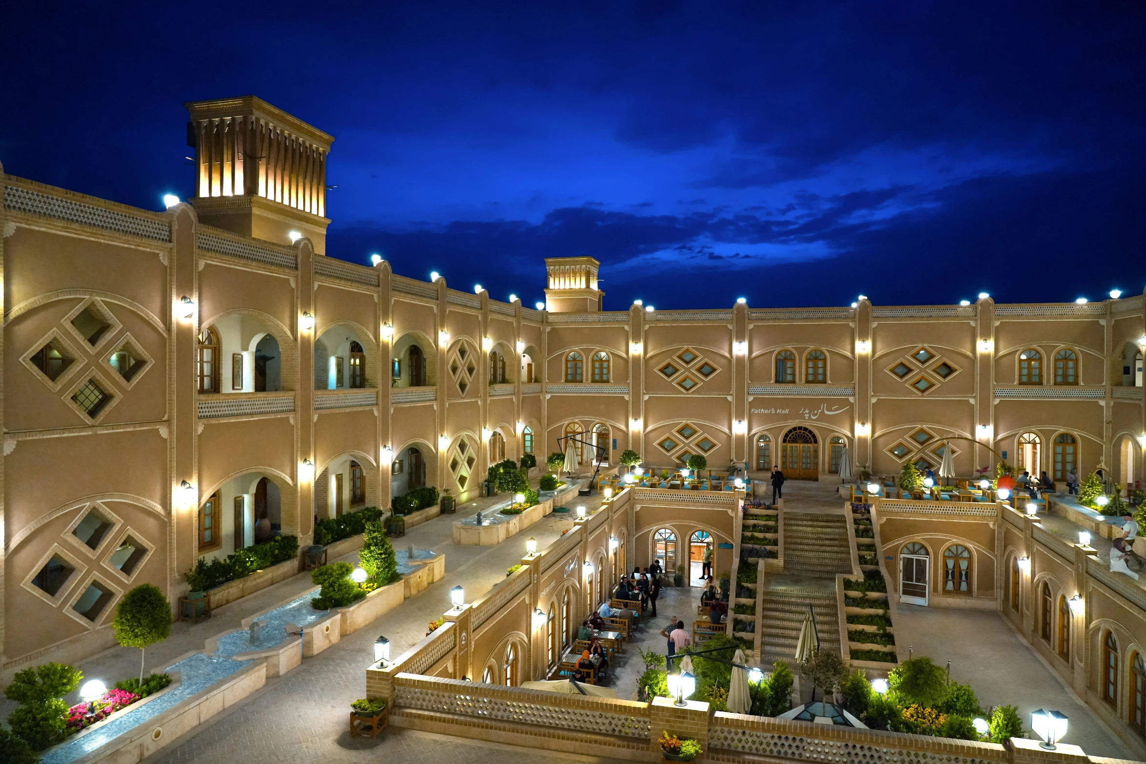 an intricately lit courtyard and staircase in the middle of a building