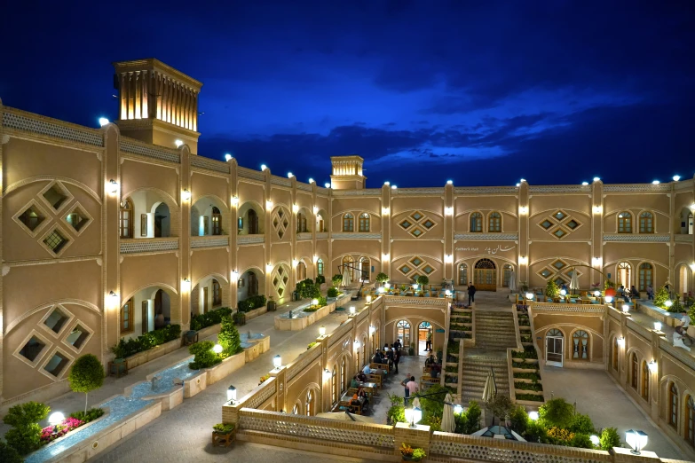 an intricately lit courtyard and staircase in the middle of a building