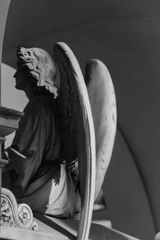 an angel statue stands against a wall and has its wings folded in front of it