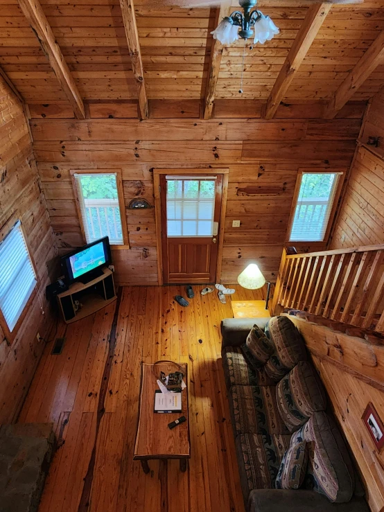 living area with couches, television and wood paneling