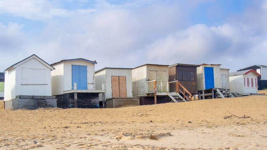 several buildings sitting on a sandy beach near water
