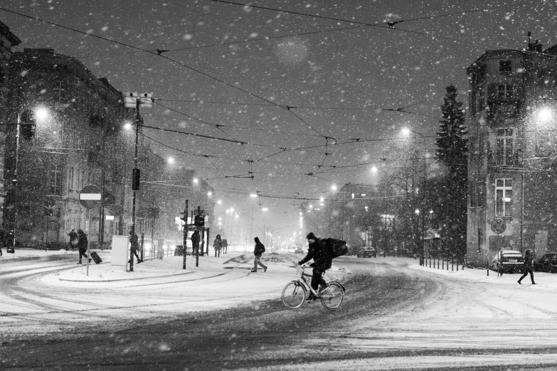 a night time scene with a man on a bicycle in the snow