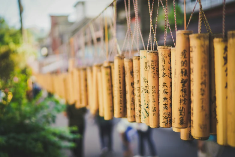 various long, yellow prayer papers with chinese writing hanging from strings