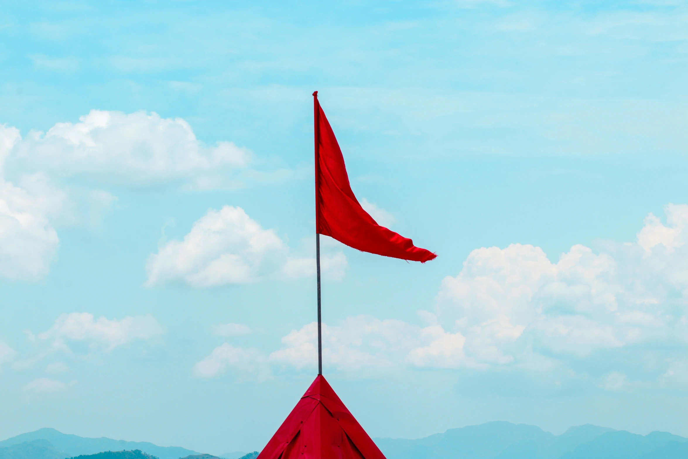 a red flag sticking out of the side of a metal pole