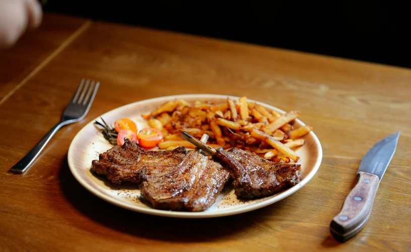 steak, fries and peppers are on a white plate