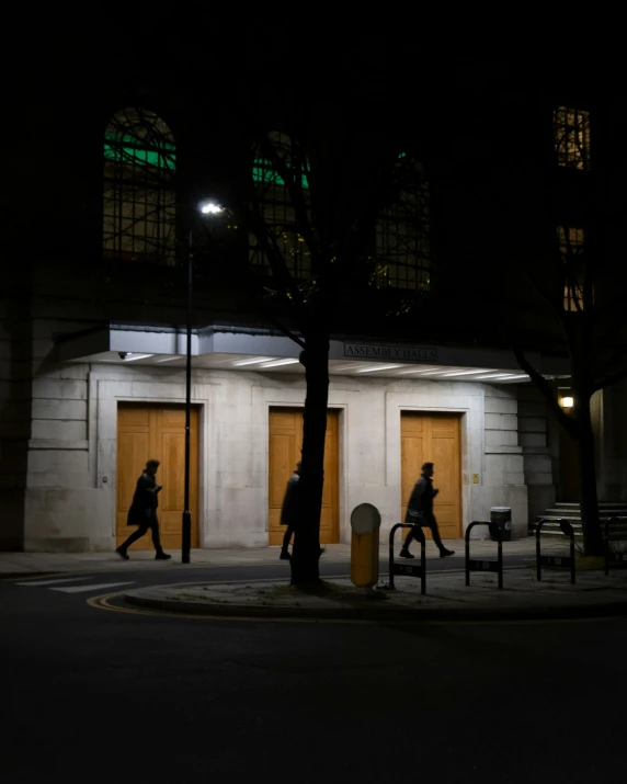 two people walking by some benches at night