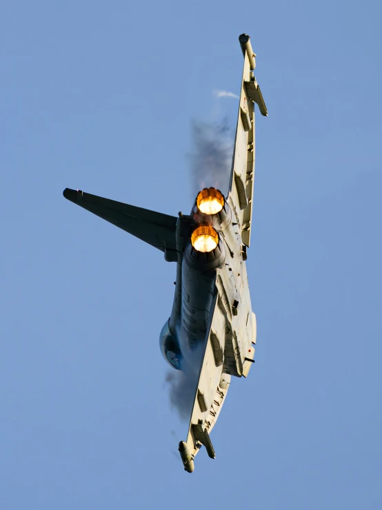 a fighter jet with a red lens in flight