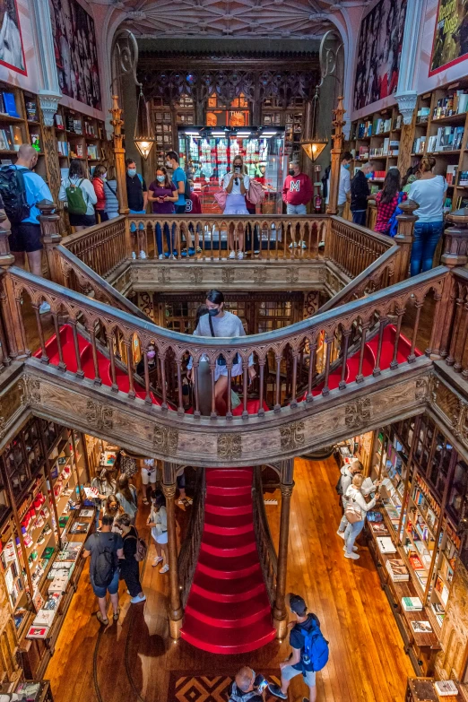 a long spiral staircase has people standing and sitting