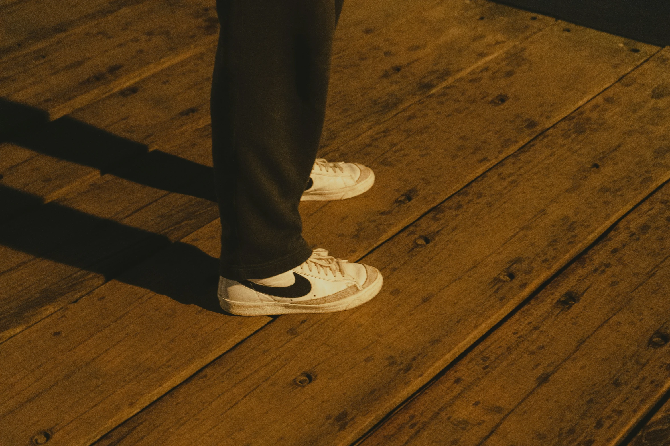 the silhouette of someone's feet on a floor in jeans