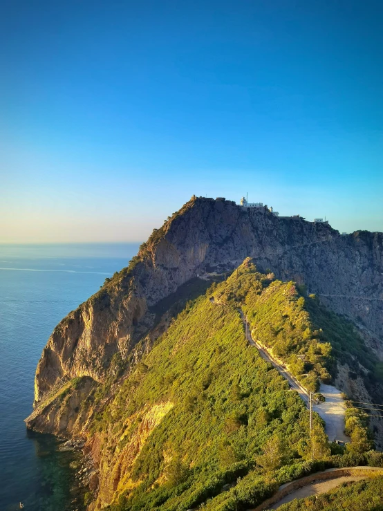 view of a lush green mountain top next to the ocean