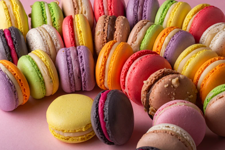 a pink table covered in macaroons and pastries