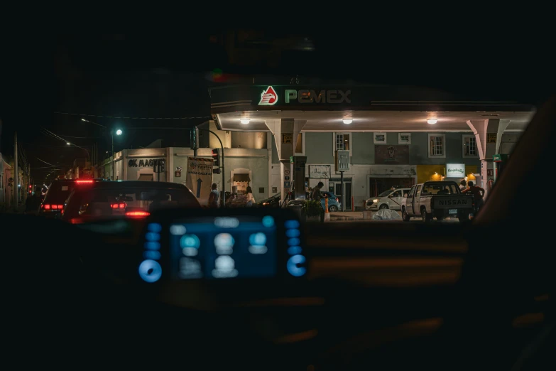 a picture of a building from behind the car in the street at night