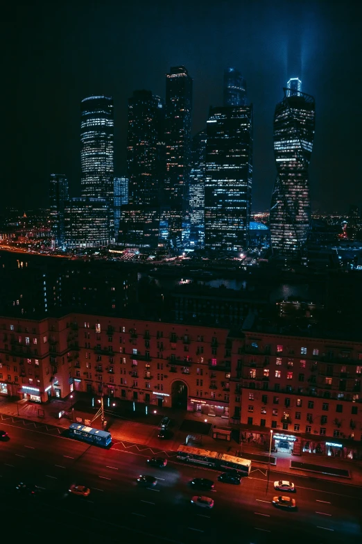 large buildings in city at night lights streaking across the sky