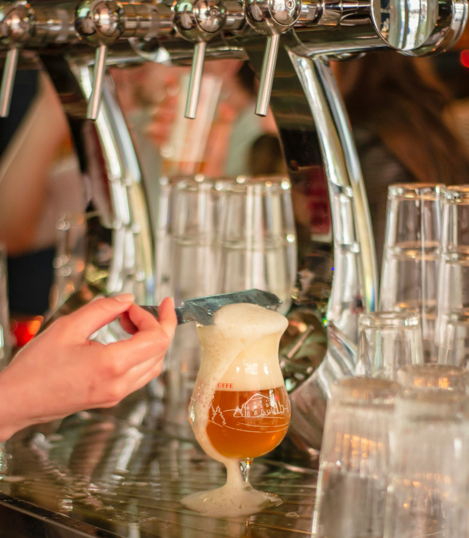 a close up of a beer being poured into a goblet