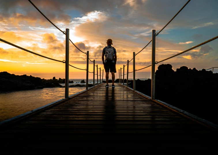 man standing on dock during the sun set