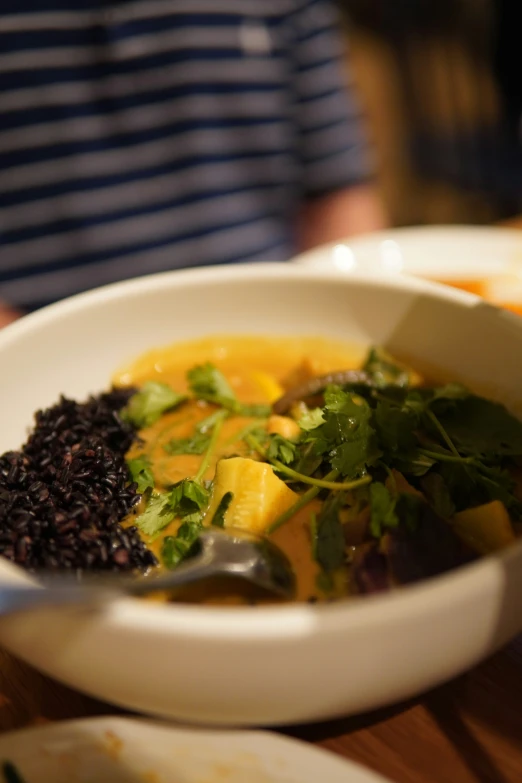 a bowl with black rice, carrots, and other items