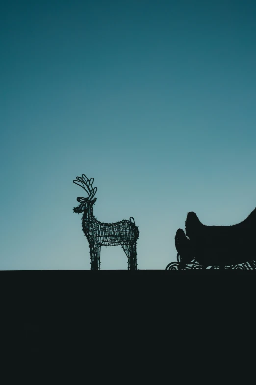 a man rides a horse drawn carriage next to a metal deer