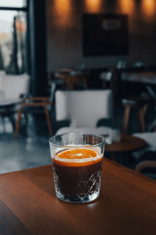 an orange sits on the table with a s glass next to it