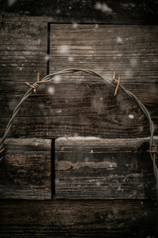 barbed wire on the side of a wooden fence