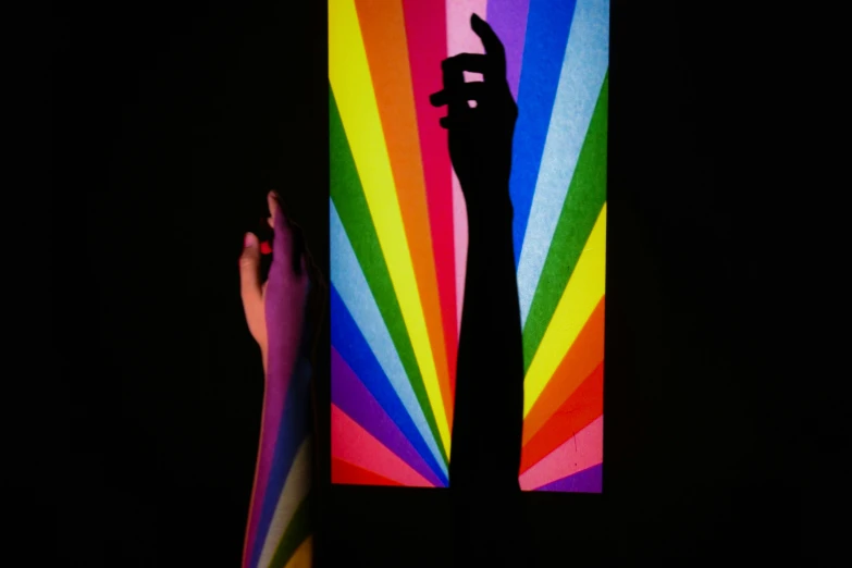 rainbow colored flag being held up by two hands