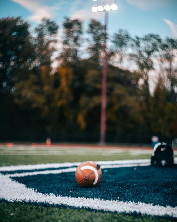 an orange soccer ball laying on the grass