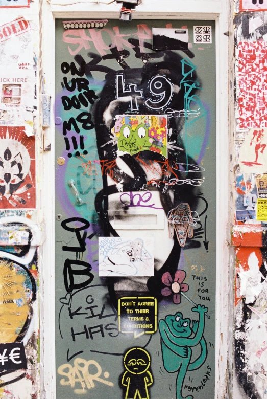 a doorway that is covered in grafitti and letters