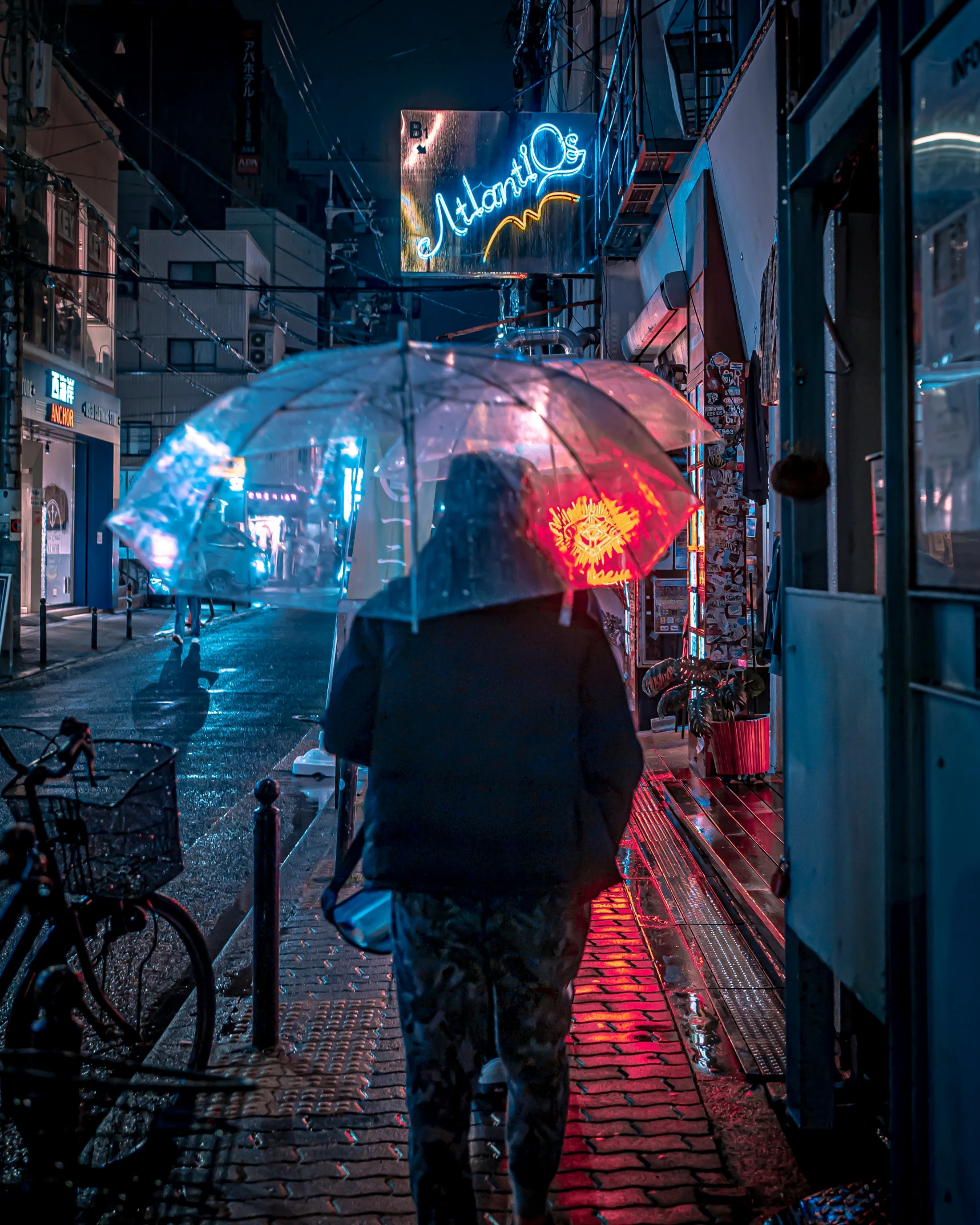 a woman in black is carrying an umbrella