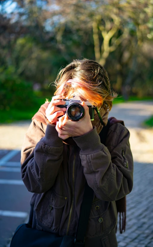 a woman with a camera standing in the street