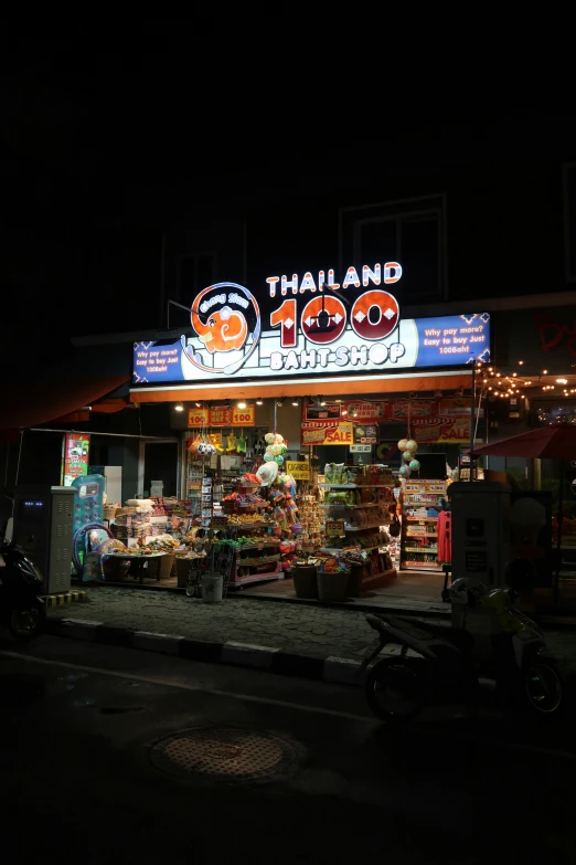 an asian food shop at night with neon signs