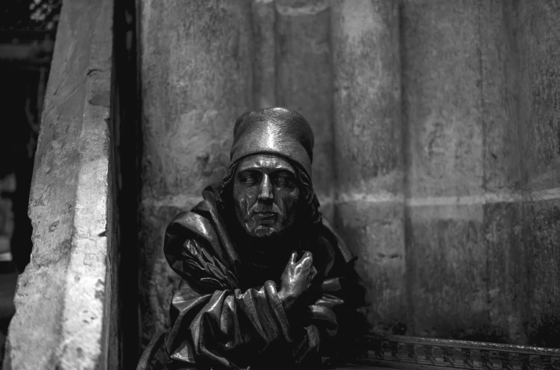 a man sitting on the ground next to a building