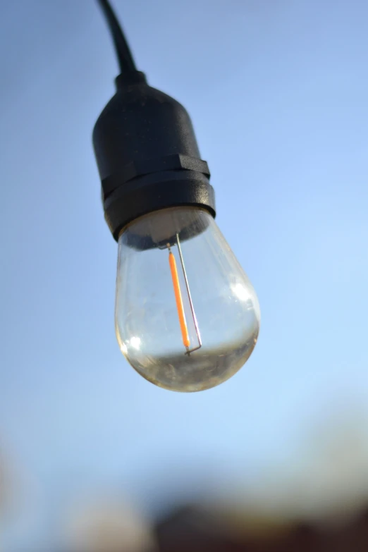 an electronic lightbulb that is hanging from a cord