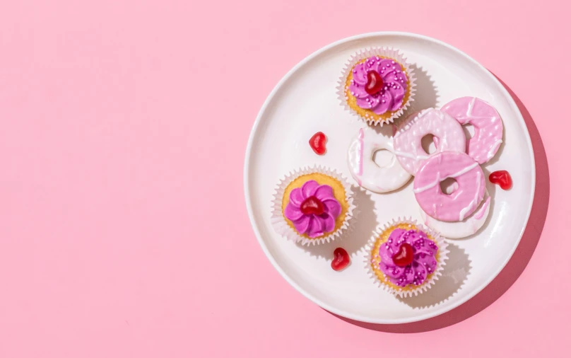 cupcakes decorated with hearts and toppings on a plate