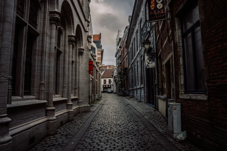 a cobblestone street leads to a row of buildings