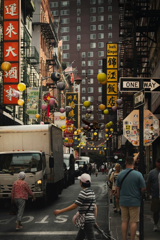 people walk down a city street with a one way sign