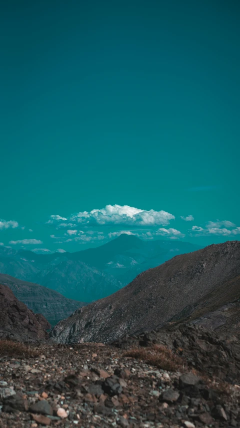 an airplane flying over rocky terrain near mountains