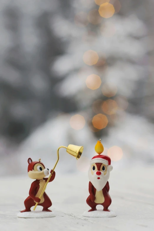 two tiny christmas figurines wearing santa hats