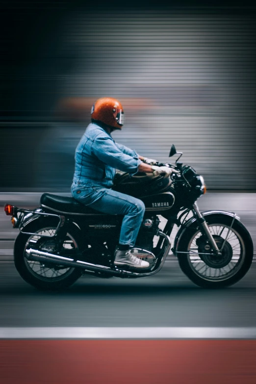 the man is sitting on the motorcycle, waiting to cross the street