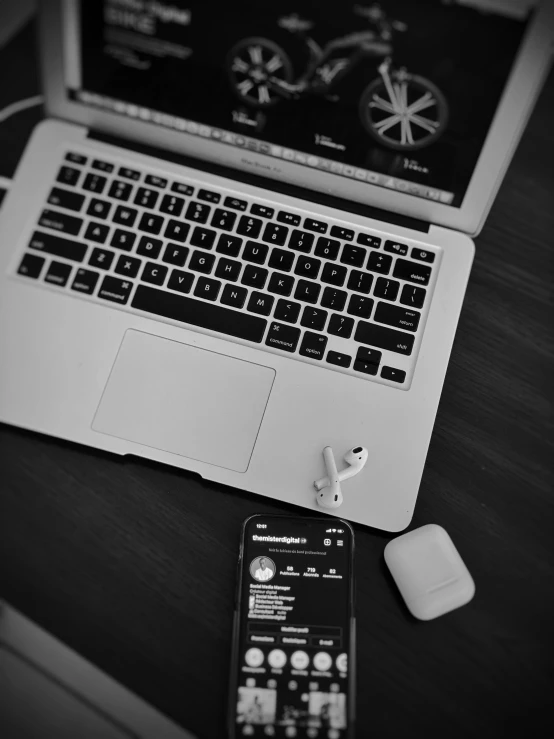 a black and white image of a keyboard and a mouse next to an apple laptop