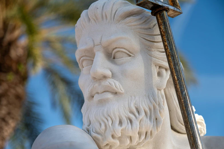 statue of a bearded man holding a small sword