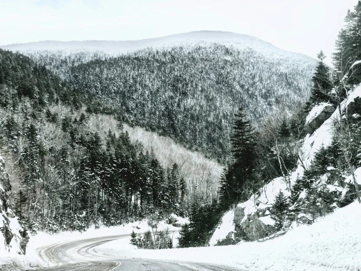 the road to the top has a snowy mountain range behind it