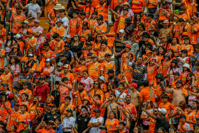 crowd of people in orange shirts on an outdoor basketball game