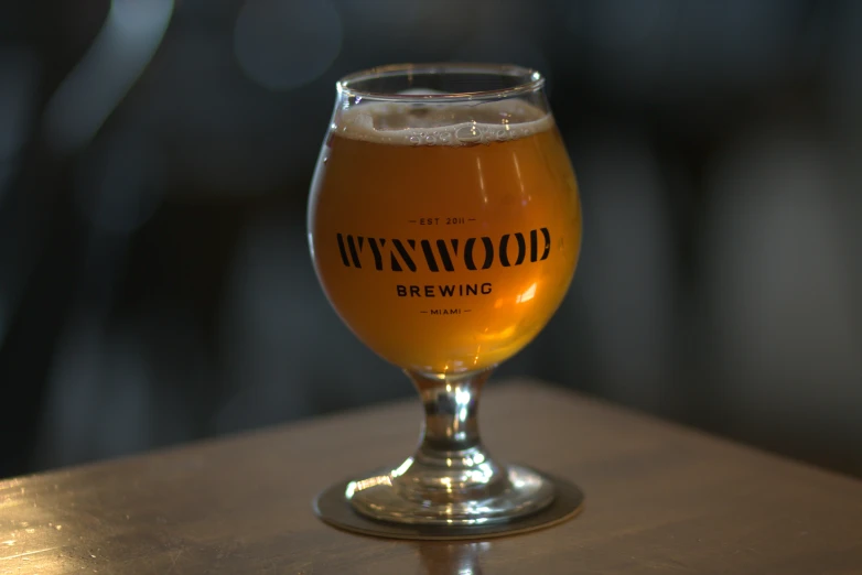 a glass on a wooden table with light behind it