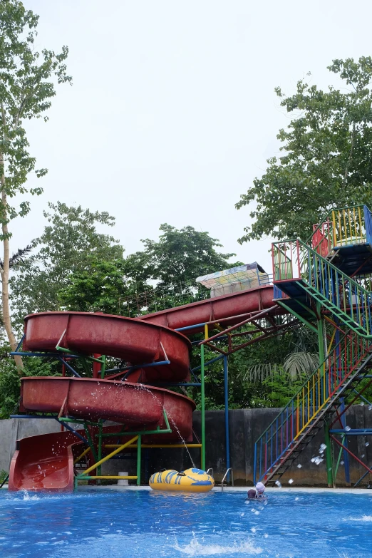 an outdoor water park with a slide, a swim board and slides