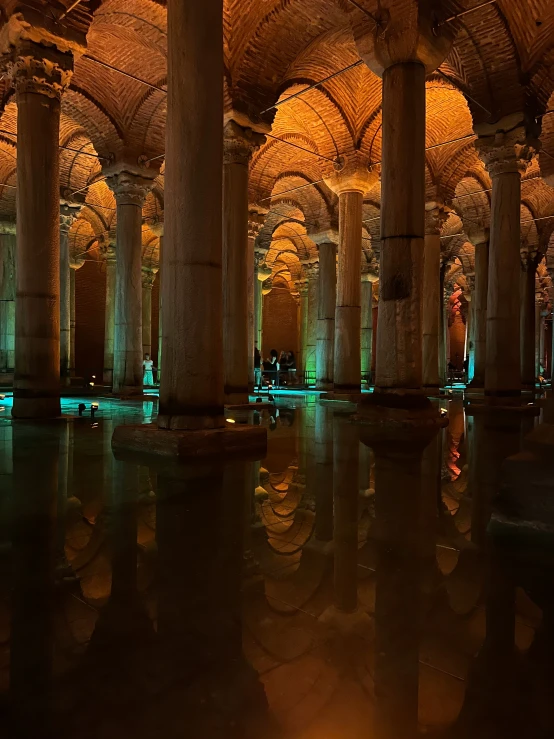 an indoor swimming area with columns and lights