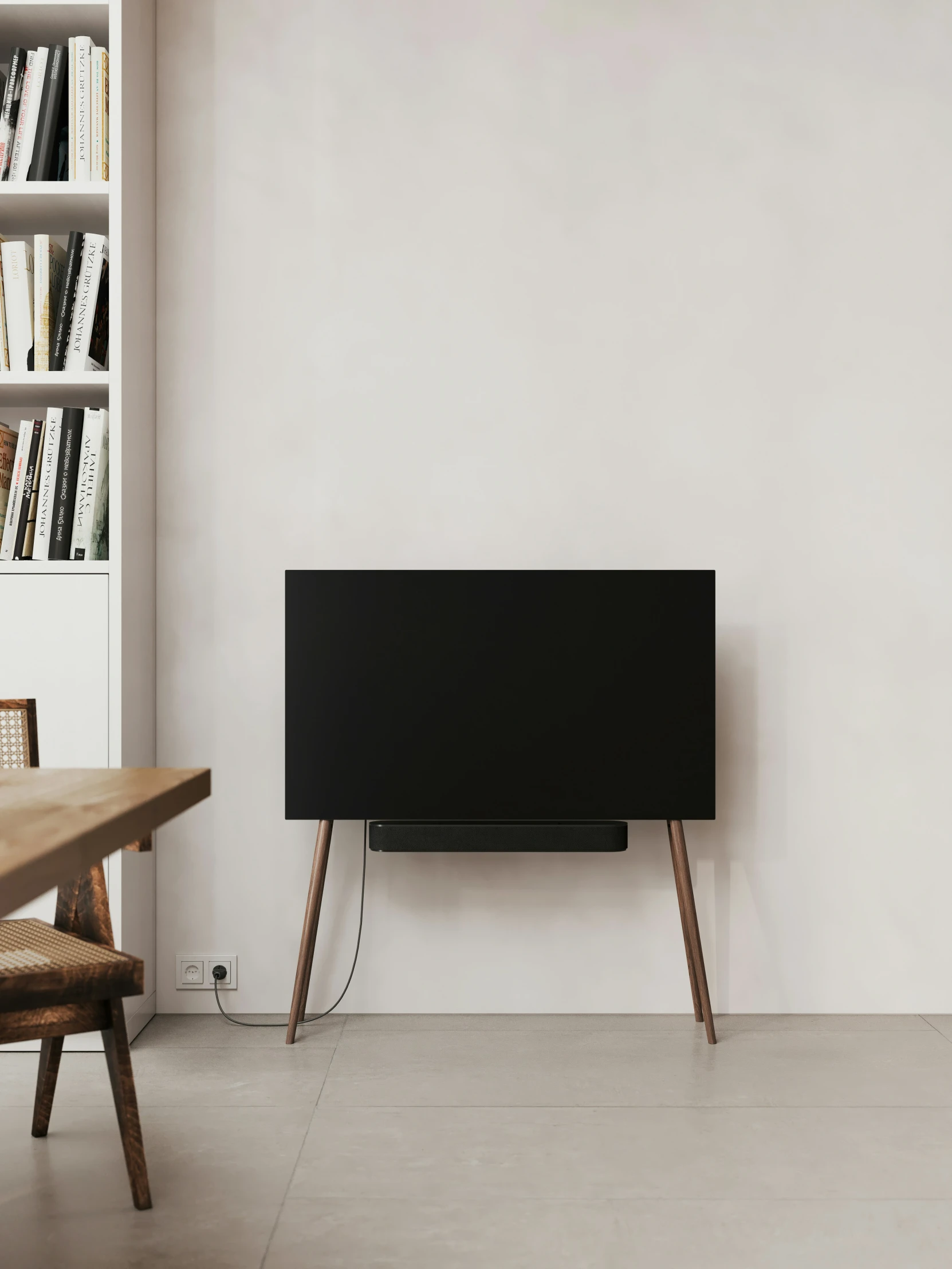 an empty room with a large television and wooden tables