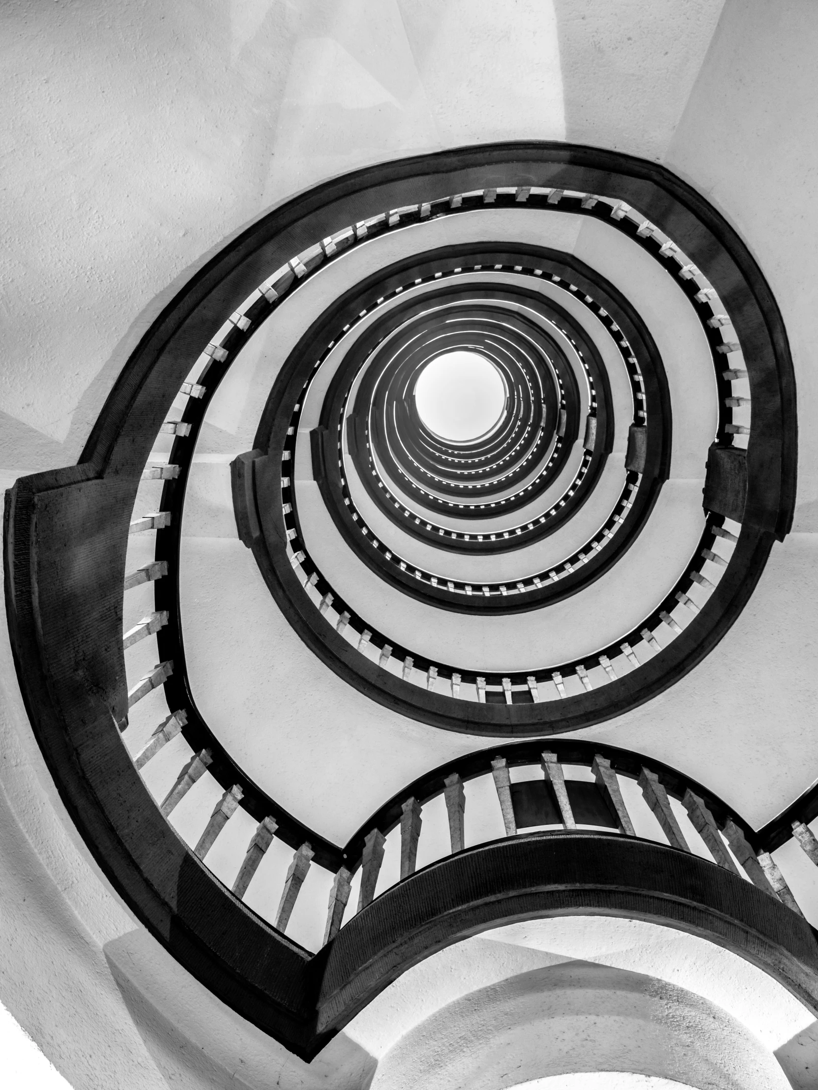 the view of a spiral stair case, seen from below