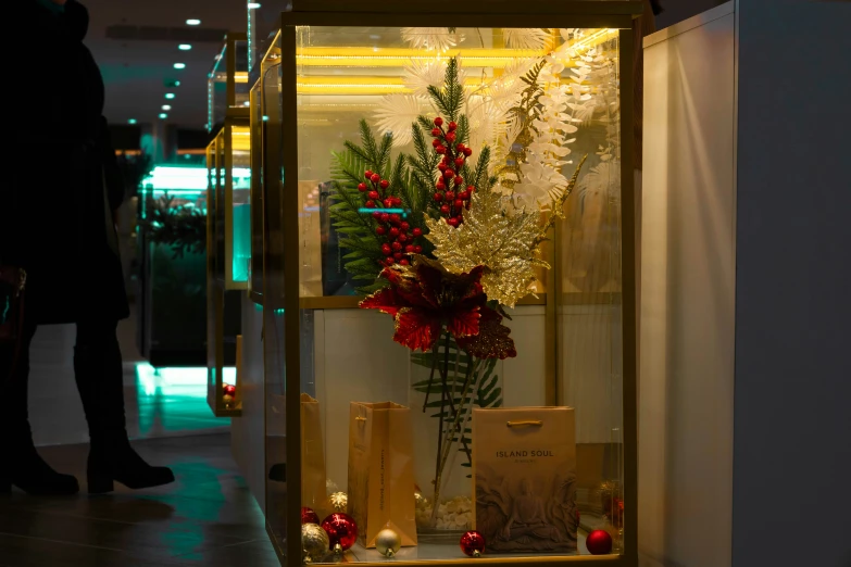 vase with some flowers and candles are in a display case